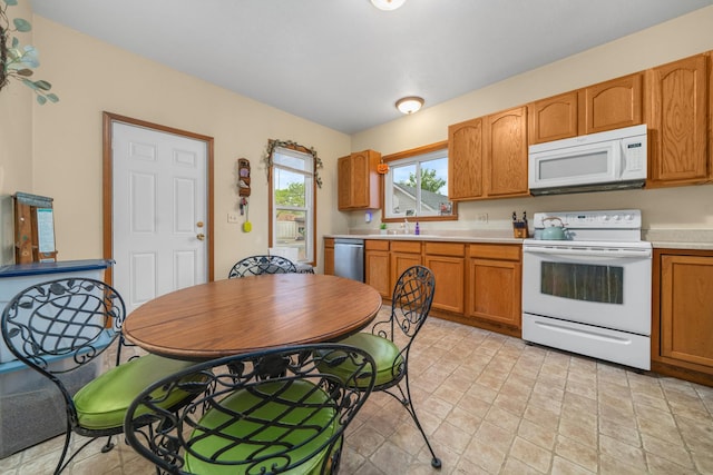620 S Main St, Belvidere, IL 61008 - kitchen featuring white appliances, light countertops, a sink, and brown cabinetry
