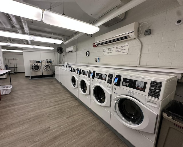 1700 E 56th St Unit 1706, Chicago, IL 60637 - shared laundry room featuring washer and clothes dryer, a wall mounted AC, and light wood-type flooring