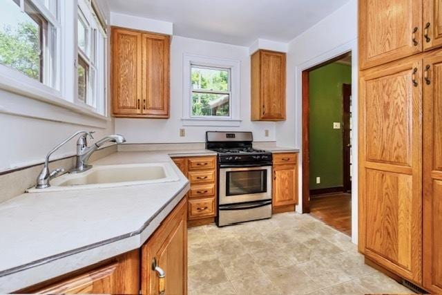 204 W Florida Ave, Urbana, IL 61801 - kitchen featuring stainless steel range with gas cooktop, brown cabinetry, and light countertops