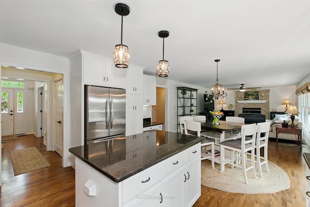 24255 Cropland Dr, Plainfield, IL 60544 - kitchen featuring freestanding refrigerator, a brick fireplace, a ceiling fan, wood finished floors, and white cabinets