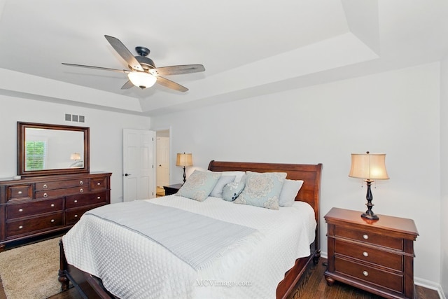 24255 Cropland Dr, Plainfield, IL 60544 - bedroom with dark wood finished floors, a tray ceiling, a ceiling fan, and baseboards