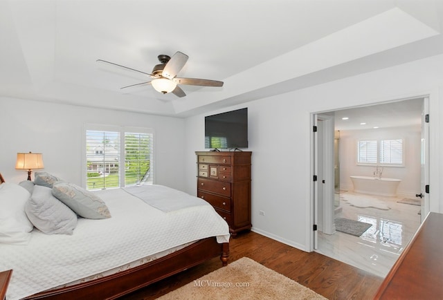 24255 Cropland Dr, Plainfield, IL 60544 - bedroom with a raised ceiling, wood finished floors, ensuite bath, baseboards, and ceiling fan