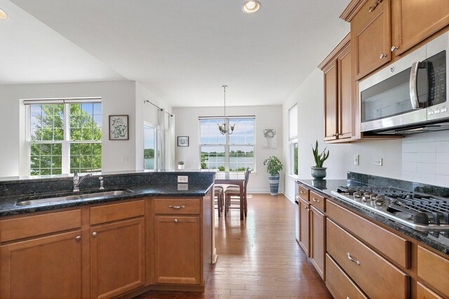 23521 N Sanctuary Club Dr, Kildeer, IL 60047 - kitchen with appliances with stainless steel finishes, healthy amount of natural light, wood finished floors, brown cabinets, and recessed lighting