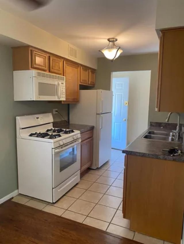 1840 W Hatherleigh Ct Unit 2D, Mount Prospect, IL 60056 - kitchen featuring white appliances, brown cabinetry, dark countertops, and light tile patterned flooring