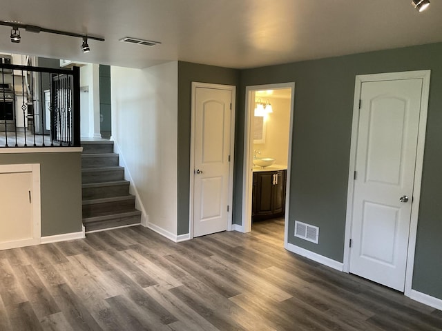 624 Catalpa Ln, Bartlett, IL 60103 - unfurnished bedroom with track lighting, wood finished floors, baseboards, a sink, and connected bathroom