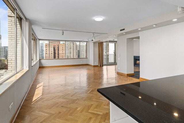 1000 N Lake Shore Plz Unit 17C, Chicago, IL 60611 - spare room with baseboards, a glass covered fireplace, and track lighting