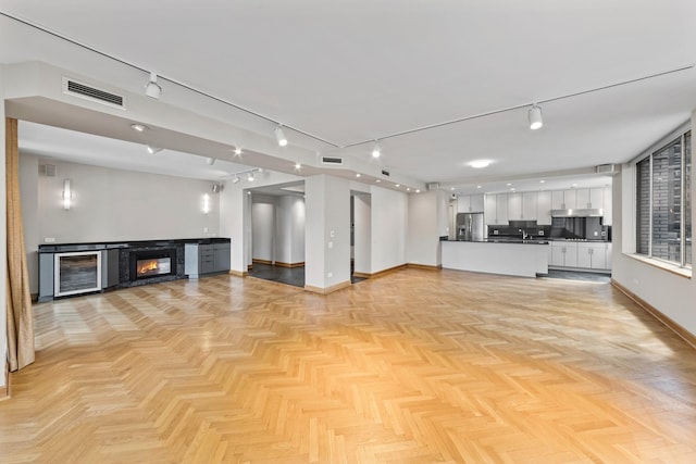 1000 N Lake Shore Plz Unit 17C, Chicago, IL 60611 - unfurnished living room featuring wine cooler, baseboards, and rail lighting