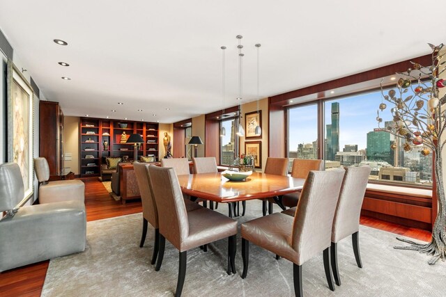 161 E Chicago Ave Unit 33De, Chicago, IL 60611 - dining space with light wood finished floors, built in shelves, a city view, and recessed lighting