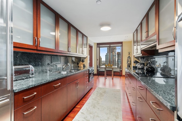 161 E Chicago Ave Unit 33De, Chicago, IL 60611 - kitchen with stainless steel fridge, black electric cooktop, tasteful backsplash, and glass insert cabinets