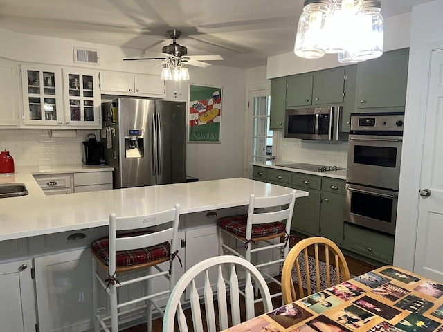 1539 Wincanton Dr, Deerfield, IL 60015 - kitchen with appliances with stainless steel finishes, decorative backsplash, ceiling fan, light countertops, and green cabinets
