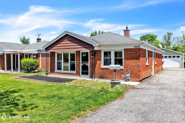 11617 S Kedzie Ave, Merrionette Park, IL 60803 - view of front facade with a chimney, brick siding, a front lawn, a detached garage, and an outbuilding