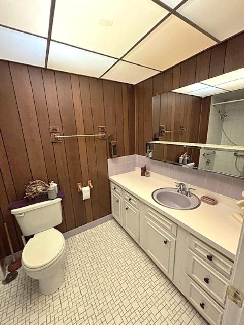 5N265 Neva Ter, Itasca, IL 60143 - bathroom featuring toilet, vanity, wood walls, and tile patterned floors