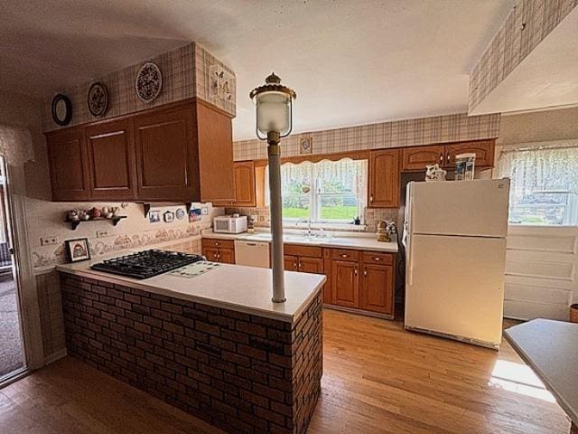 5N265 Neva Ter, Itasca, IL 60143 - kitchen with white appliances, light wood-style flooring, light countertops, a peninsula, and brown cabinetry