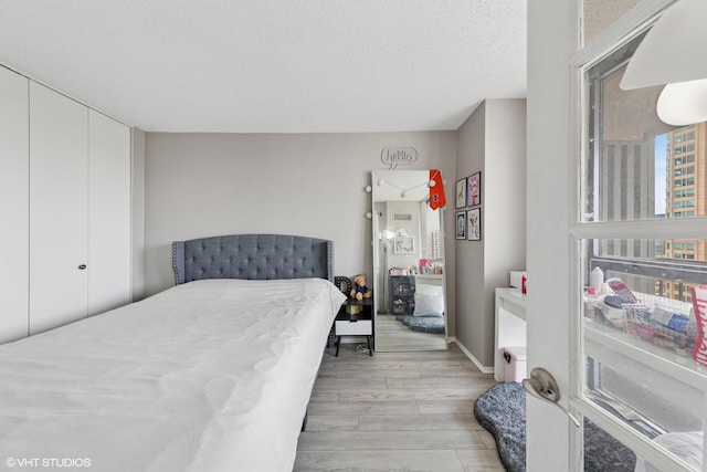 10 E Ontario St Unit 2806, Chicago, IL 60611 - bedroom with light wood-style flooring and a textured ceiling