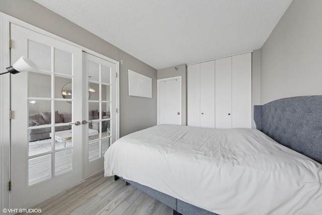 10 E Ontario St Unit 2806, Chicago, IL 60611 - bedroom featuring light wood-style floors, french doors, a closet, and a textured ceiling