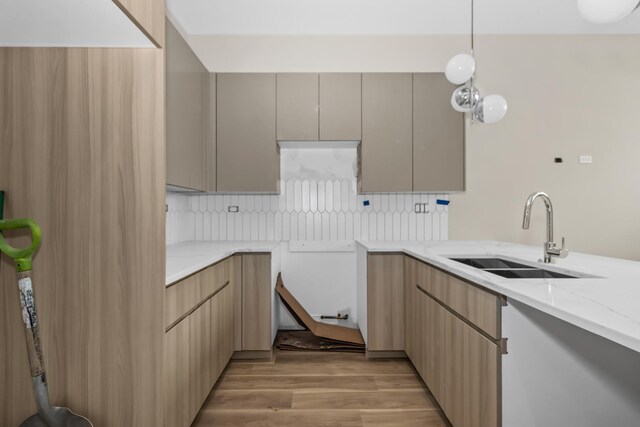 6513 S Langley Ave, Chicago, IL 60637 - kitchen with a sink, backsplash, light stone countertops, light wood-style flooring, and hanging light fixtures