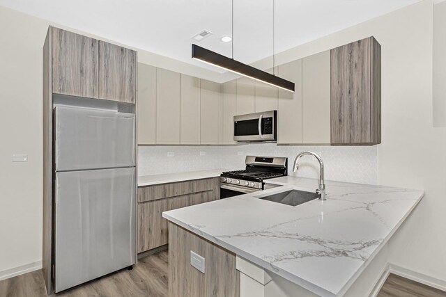 6513 S Langley Ave, Chicago, IL 60637 - kitchen featuring stainless steel appliances, a sink, modern cabinets, a peninsula, and light wood finished floors