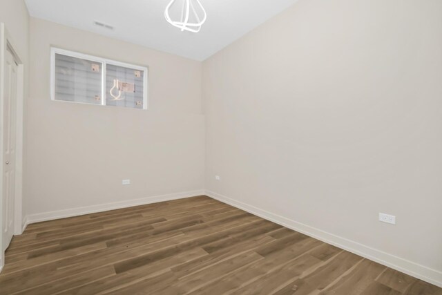 6513 S Langley Ave, Chicago, IL 60637 - spare room featuring wood finished floors, baseboards, and a chandelier