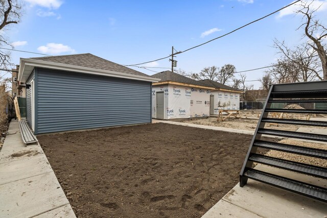 6513 S Langley Ave, Chicago, IL 60637 - view of side of property featuring a shingled roof and an outdoor structure