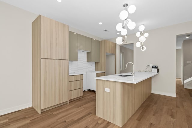 6513 S Langley Ave, Chicago, IL 60637 - kitchen featuring a sink, a peninsula, modern cabinets, light wood-style floors, and baseboards