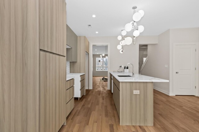6513 S Langley Ave, Chicago, IL 60637 - kitchen with modern cabinets, a sink, light wood finished floors, and light stone countertops
