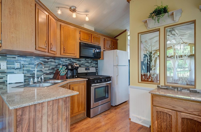 166 Fossil Cove Ln, Wilmington, IL 60481 - kitchen with black microwave, stainless steel range with gas cooktop, a sink, freestanding refrigerator, and light stone countertops