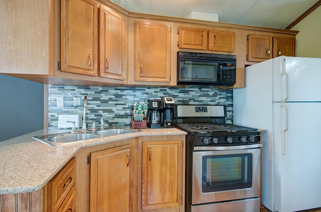 166 Fossil Cove Ln, Wilmington, IL 60481 - kitchen with black microwave, stainless steel gas range, freestanding refrigerator, tasteful backsplash, and a sink