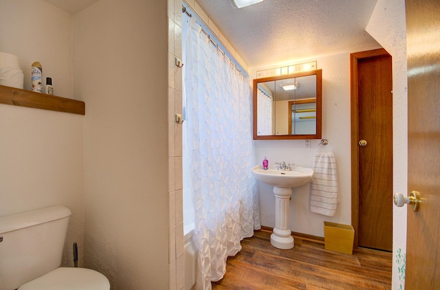 166 Fossil Cove Ln, Wilmington, IL 60481 - bathroom with wood finished floors, toilet, shower / bathtub combination with curtain, baseboards, and a sink