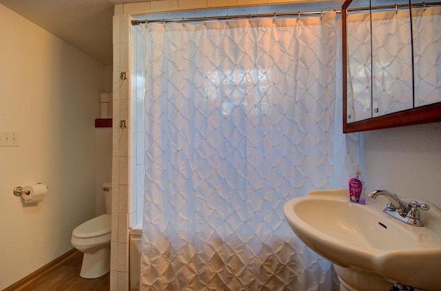 166 Fossil Cove Ln, Wilmington, IL 60481 - full bath featuring toilet, wood finished floors, shower / tub combo, a sink, and baseboards