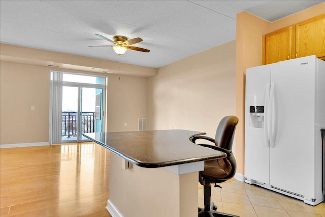 9355 Irving Park Rd Unit 506, Schiller Park, IL 60176 - kitchen with white fridge with ice dispenser, a ceiling fan, dark countertops, a breakfast bar area, and an office area