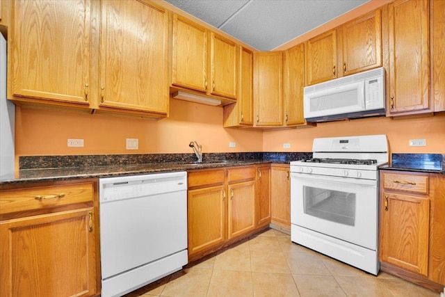 9355 Irving Park Rd Unit 506, Schiller Park, IL 60176 - kitchen featuring white appliances, light tile patterned floors, and dark stone countertops