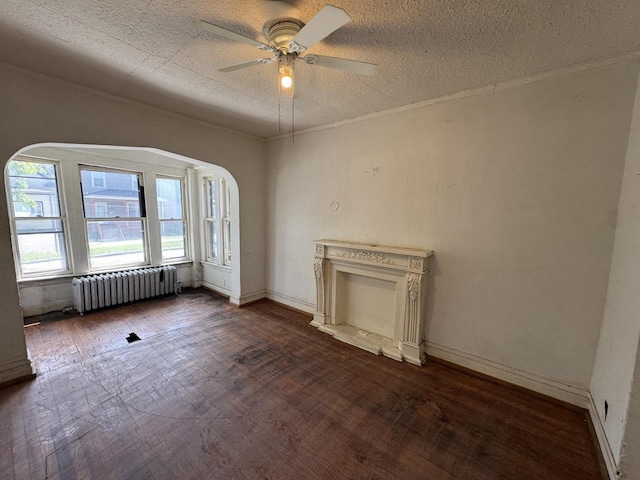 7514 S Rhodes Ave, Chicago, IL 60619 - unfurnished living room with radiator heating unit, ceiling fan, dark wood-type flooring, arched walkways, and crown molding