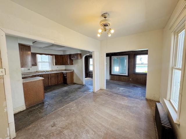 7514 S Rhodes Ave, Chicago, IL 60619 - kitchen with radiator heating unit, a chandelier, light countertops, a sink, and stone tile floors