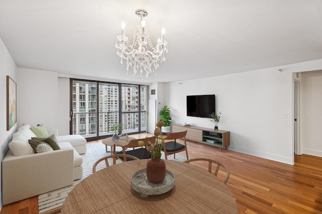 10 E Ontario St Unit 3609, Chicago, IL 60611 - dining room featuring a chandelier, baseboards, light wood-type flooring, and a wall of windows