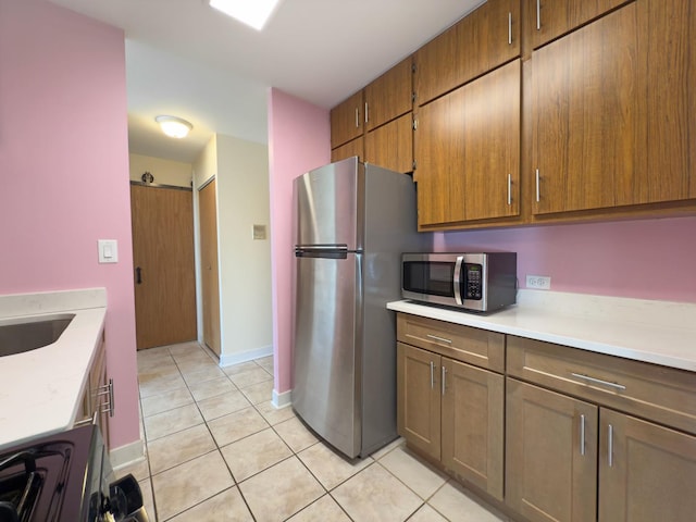 33 N Main St Unit 4J, Lombard, IL 60148 - kitchen with appliances with stainless steel finishes, light tile patterned floors, light countertops, and brown cabinetry