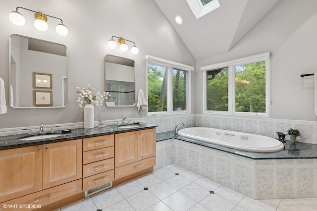 1543 Shawnee Trl, Riverwoods, IL 60015 - bathroom featuring lofted ceiling, a bath, double vanity, a skylight, and tile patterned flooring
