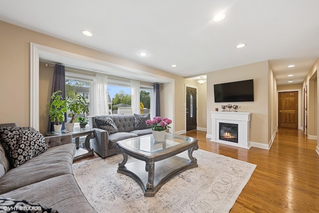 5112 N Canfield Ave, Norridge, IL 60706 - living room with light wood-style floors, baseboards, a glass covered fireplace, and recessed lighting
