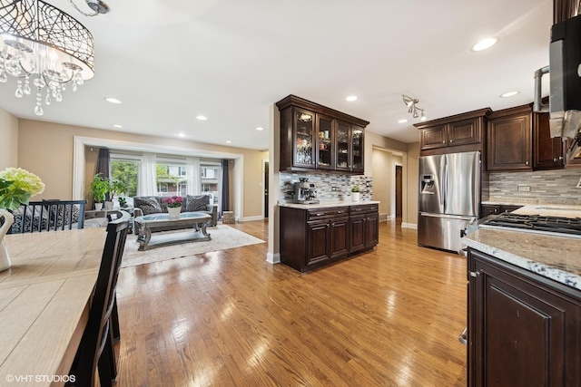 5112 N Canfield Ave, Norridge, IL 60706 - kitchen with stainless steel refrigerator with ice dispenser, dark brown cabinets, light wood-style flooring, tasteful backsplash, and open floor plan