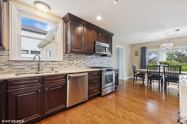 5112 N Canfield Ave, Norridge, IL 60706 - kitchen featuring appliances with stainless steel finishes, a sink, decorative backsplash, and dark brown cabinets