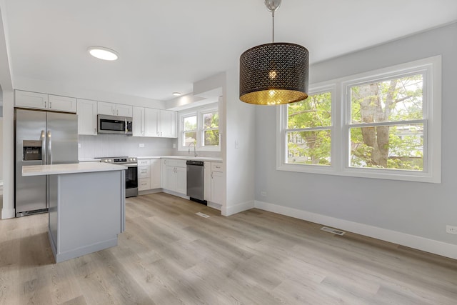 104 N Braintree Dr, Schaumburg, IL 60194 - kitchen with appliances with stainless steel finishes, a sink, light countertops, baseboards, and white cabinetry
