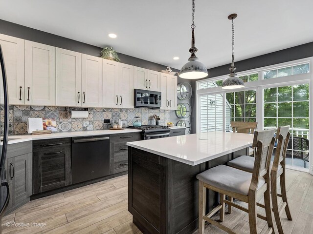 1016 Hummingbird Way, Bartlett, IL 60103 - kitchen featuring appliances with stainless steel finishes, light countertops, decorative backsplash, light wood-style floors, and recessed lighting