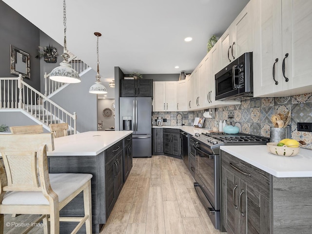 1016 Hummingbird Way, Bartlett, IL 60103 - kitchen featuring black appliances, a sink, light wood-style floors, light countertops, and recessed lighting