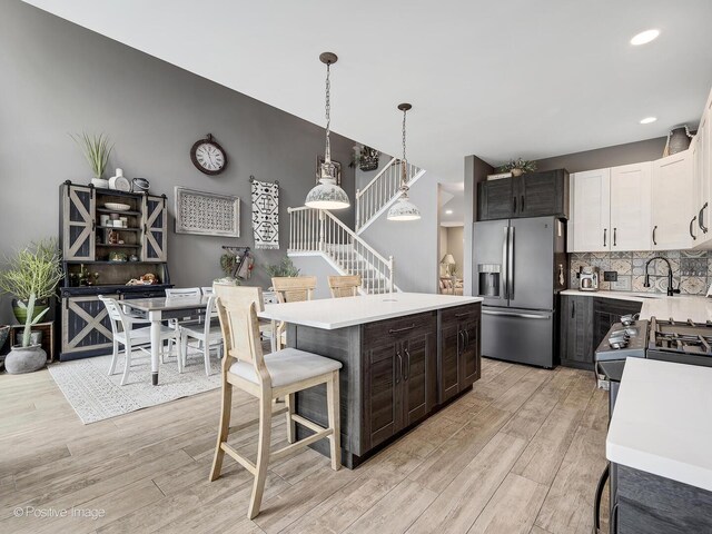 1016 Hummingbird Way, Bartlett, IL 60103 - kitchen with stainless steel fridge with ice dispenser, light countertops, light wood-style floors, decorative backsplash, and recessed lighting