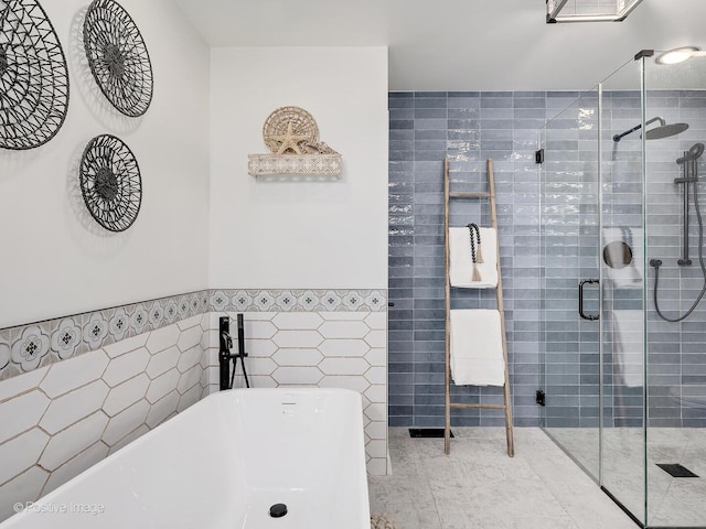 1016 Hummingbird Way, Bartlett, IL 60103 - bathroom featuring tile walls, a freestanding bath, a stall shower, and a wainscoted wall