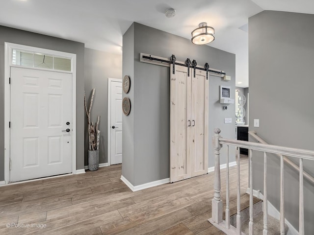 1016 Hummingbird Way, Bartlett, IL 60103 - foyer entrance with a barn door, wood finished floors, and baseboards