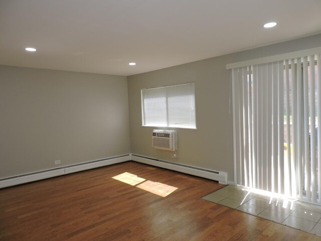 703 E Fullerton Ave Unit 1-110, Glendale Heights, IL 60139 - empty room featuring a baseboard heating unit, wood finished floors, recessed lighting, and a wall mounted air conditioner