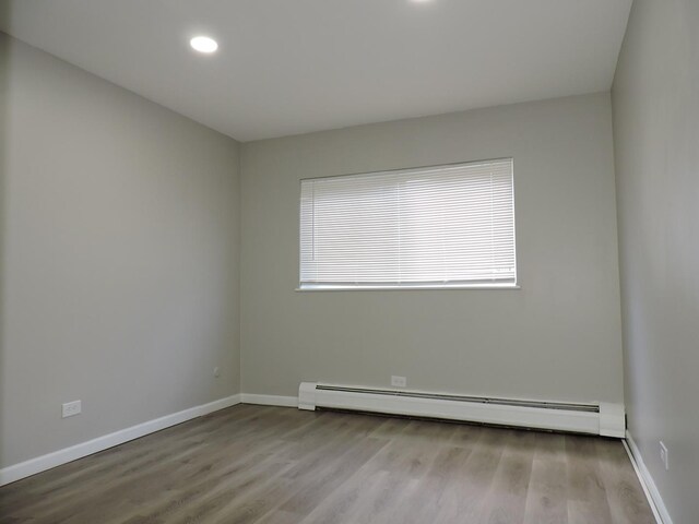703 E Fullerton Ave Unit 1-110, Glendale Heights, IL 60139 - empty room with baseboard heating, healthy amount of natural light, wood finished floors, and recessed lighting