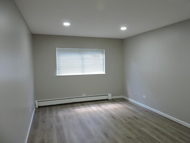 703 E Fullerton Ave Unit 1-110, Glendale Heights, IL 60139 - unfurnished room featuring a baseboard radiator, wood finished floors, and recessed lighting