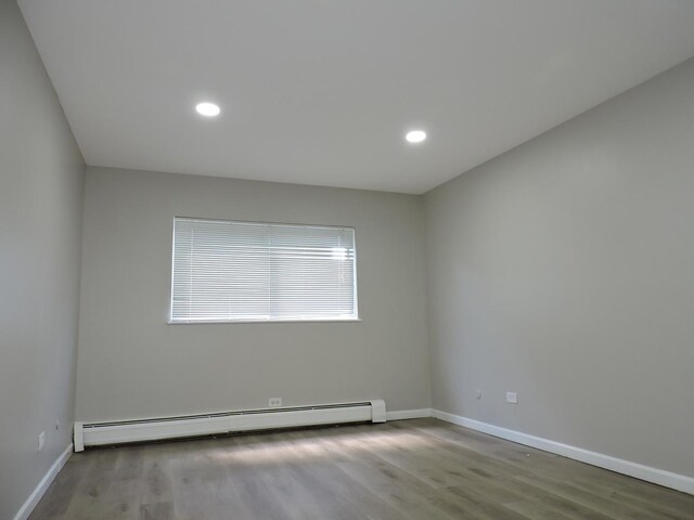 703 E Fullerton Ave Unit 1-110, Glendale Heights, IL 60139 - unfurnished room featuring a baseboard radiator, wood finished floors, and recessed lighting
