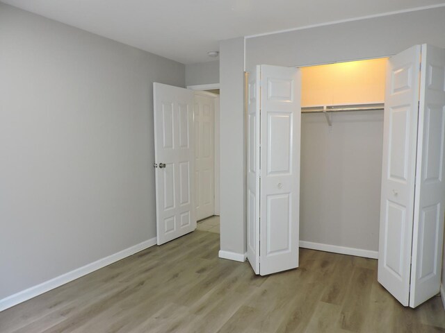 703 E Fullerton Ave Unit 1-110, Glendale Heights, IL 60139 - unfurnished bedroom with light wood finished floors and a closet